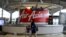 FILE - A woman walks past an AirAsia counter at Kuala Lumpur International Airport in Sepang, Malaysia, July 22, 2019. 