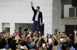 FILE - Opposition leader Juan Guaido waves to supporters during a rally at Bolivar Plaza in Chacao, Venezuela, Feb. 11, 2020.
