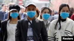 អ្នកទេសចរពាក់ម៉ាស់ពេលមកទស្សនាបឹង Hoan Kiem ក្នុងក្រុងហាណូយ ប្រទេសវៀតណាម កាលពីថ្ងៃទី៣១ ខែមករា ឆ្នាំ២០២០។