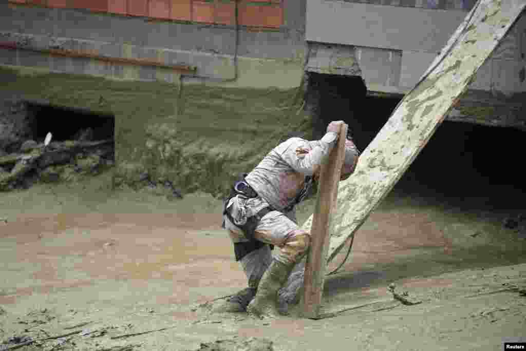 A Volunteer Search and Rescue Service (SAR) member helps in the Inca Llojeta area, which was affected by floodings, in the aftermath of landslides caused by intense rains and illegal earth movements, in La Paz, Bolivia.