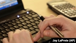 Seorang siswa sedang belajar dengan komputer dan kalkulator di Sekolah Menengah Reynoldsburg di Reynoldsburg, Ohio, AS, sebagai ilustrasi. (Foto: AP/Jay LaPrete)
