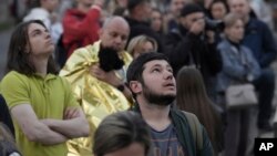 ຊາວເມືອງພາກັນຍົກຍ້າຍ ເບິ່ງອາພາດເມັນເຂົາເຈົ່້າຫລາຍຊັ້ນ ທີ່ຖືກທຳລາຍຈາກການໂຈມຕີ ໃນນະຄອນກິຢິບ ປະເທດຢູເຄນ ວັນທີ 30 ພຶດສະພາ 2023 