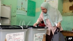 An Egyptian casts her vote in the first round of parliamentary elections at polling station in Giza, Cairo, Egypt, Oct. 18, 2015.