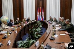 Menteri Pertahanan Inggris Ben Wallace, kedua kiri, dan Menteri Pertahanan Rusia Sergei Shoigu, kedua kanan, berbicara satu sama lain selama pertemuan mereka di Moskow, Rusia, Jumat, 11 Februari 2022. (Foto: via AP)