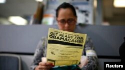 FILE - Arminda Murillo, 54, reads a leaflet on Obamacare at a health insurance enrollment event in Cudahy, Calif., March 27, 2014. 