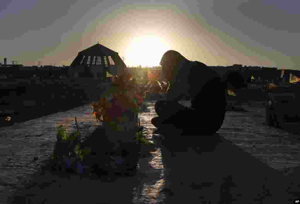 A Kurdish man mourns as he sits next to the grave of a friend who was killed while fighting against Islamic State militants in Raqqa, at a cemetery in Kobani, Syria.