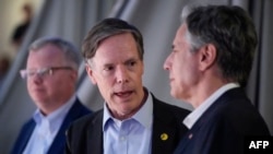 Dubes AS untuk China Nicholas Burns (tengah) sedang berbincang dengan Menteri Luar Negeri AS Antony Blinken sambil menontong pertandingan basket antara klub Shanghai Sharks dan Zhejiang Golden Bulls di Shanghai, 24 April 2024. (Foto: Mark Schiefelbein/pool/AFP)