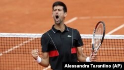 Novak Đoković slavi osvajanje poena protiv Španca Roberta Bautista-Aguta u trećem kolu Rolan Garosa, 1. juna 2018. godine (Foto: AP/Alessandra Tarantino)