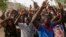 People displaced following attacks by Islamist militants raise their arms as they pass through security before casting their votes, in Yola, Nigeria, March 28, 2015.