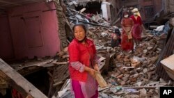 Warga berusaha mencari barang-barang di antara reruntuhan rumahnya akibat gempa di Bhaktapur, Nepal (3/5). (AP/Bernat Amangue)