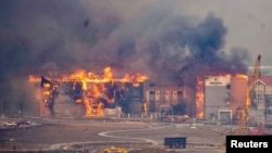 Structures burn, including an Element Hotel, as a wind-driven wildfire forced evacuation of the Superior suburb of Boulder, Colorado, Dec. 30, 2021. 