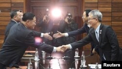 ប្រធានការិយាល័យ​សិល្ប​សម្តែង​លោកនៃ​ក្រសួង​វប្បធម៌​កូរ៉េ​ខាងជើង​ចាប់ដៃ​ជាមួយ​លោក Lee Woo-sung គណប្រតិភូ​កូរ៉េ​ខាង​ត្បូង​បន្ទាប់ពី​ចប់​កិច្ច​ប្រជុំ​ Tongilgak។