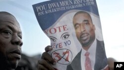 A supporter of Haitian lawmaker Deputy Arnel Belizaire holds up a poster while waiting outside the Toussaint Louverture International Airport where Belizaire was detained by Haitian police in Port-au-Prince October 27, 2011.