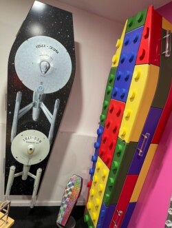 This photo provided by Ross Hall, shows caskets shaped as Lego and a space ship in Auckland, New Zealand, on Feb 25, 2021. (Ross Hall via AP)