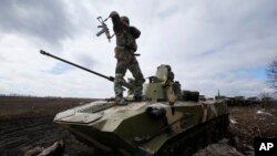 A Ukrainian soldier stands atop an armored vehicle at a military camp near the village of Michurino, Ukraine, March 17, 2014.