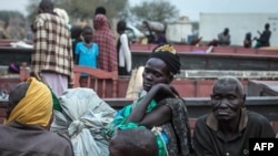 Warga di Minkammen, Sudan Selatan, mengangkut sedikit harta bendanya untuk mengungsi (9/1). (AFP/Nichole Sobecki)