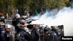 Polisi mengarahkan senjata mereka ke demonstran anti-pemerintah dalam bentrokan di Gedung Pemerintah di Bangkok (18/2). (Reuters/Athit Perawongmetha)