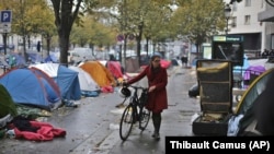 Une femme emprunte une ruelle aux abords de laquelle des migrants ont installé leurs tentes, Paris, le 4 novembre 2016.