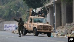 Para pejuang pro-pemerintah mengambil posisi di jalanan saat terjadi tembak menembak dengan pemberontak Houthi, di Taiz, Yaman, (15/12).