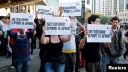 Residents hold up signs that read, "Metro workers: The people support you," outside Ana Rosa subway station during the fifth day of metro worker's strike in Sao Paulo, Brazil, June 9, 2014.