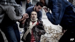 Čovek pomaže ranjenom civilu u napadu na Alepo u Siriji