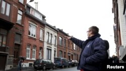 A resident points at a house located in a street called "Rue du Fort" in Charleroi, Belgium, Jan. 13, 2016. 