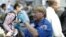 A TSA agent looks over a license at a security check point.