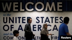 FILE - International passengers arrive at Washington Dulles International Airport, in Dulles, Virginia, June 26, 2017. 