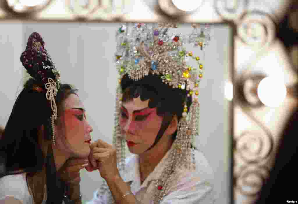 Para penari bersiap-siap dalam pertunjukan opera China untuk para lansia menjelang tahun baru Imlek di Singapura. Acara ini diselenggarakan oleh Shan You, sebuah organisasi sukarela yang menggalakkan dana untuk memberikan layanan mereka bagi orang tua. 