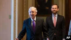 Senate Majority Leader Mitch McConnell of Ky., left, walks from the Senate Floor on Capitol Hill, Feb. 4, 2020 in Washington.