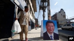 资料照片:一名尼泊尔男性路过摆在加德满都街头的中国国家主席习近平的肖像。（2019年10月11日）