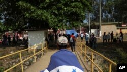 Seorang migran Amerika Tengah dari Honduras mengenakan bendera negaranya saat berlangsungnya program tahunan "Via crucis" yang diselenggarakan oleh kelompok aktivis "Pueblo Sin Fronteras" di Matias Romero, negara bagian Oaxaca, Meksiko, Senin, 2 April 2018.
