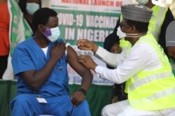 FILE - Dr. Ngong Cyprian, left, is the first Nigerian to receive the first dose of the Oxford/AstraZeneca vaccine at the National Hospital Abuja, Nigeria, March 5, 2021.