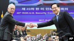 U.S. Defense Secretary Jim Mattis, left, and South Korean Defense Minister Song Young-moo shake hands while posing for a photo before the 49th Security Consultative Meeting at Defense Ministry in Seoul, South Korea, Oct. 28, 2017.