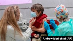 Seorang anak laki-laki menerima vaksin COVID-19 Pfizer dalam program vaksinasi untuk anak usia 5-11 tahun di Roma, Italia, pada 15 Desember 2021. (Foto: AP/Andrew Medichini)