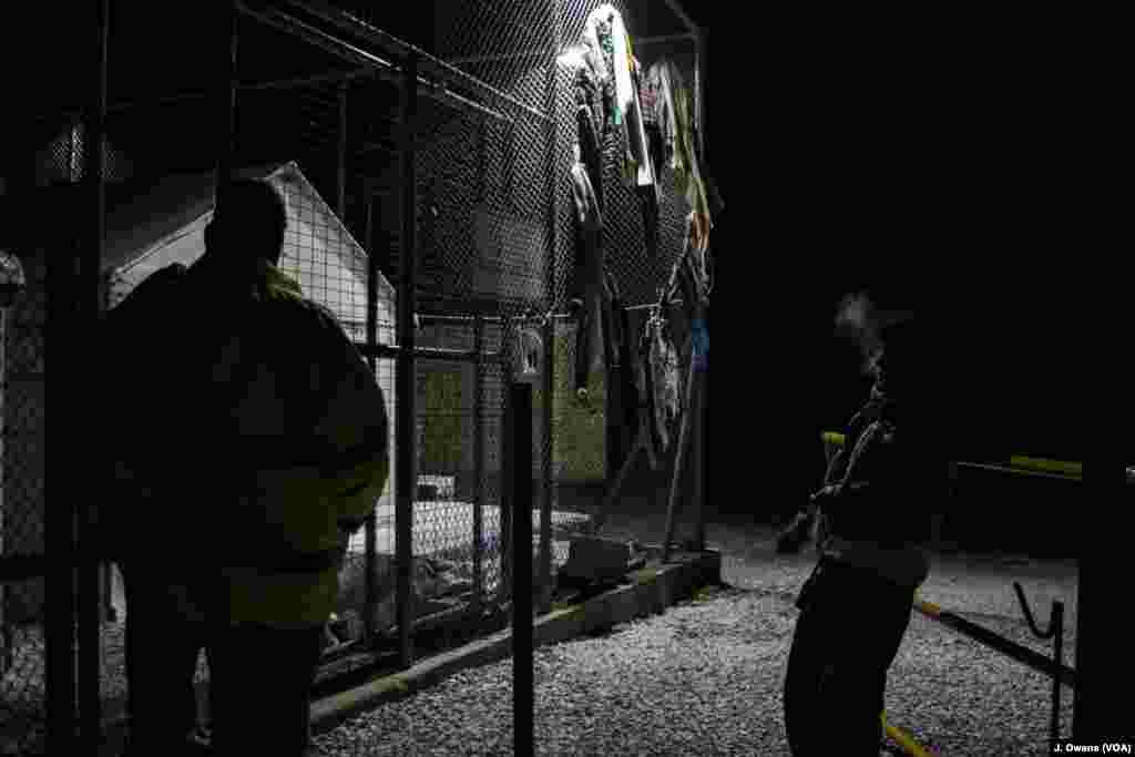 A volunteer and security guard stand outside one of Lesvos’ temporary camps, which became an overnight stop for newly-arrived refugees amid reports Moria was full. 
