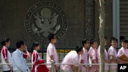 In this May 2, 2012 file photo, Chinese students wait outside the U.S. Embassy for their visa application interviews in Beijing. (AP Photo/Alexander F. Yuan)