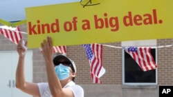 FILE - Census worker Marisela Gonzales adjusts a sign at a U.S. Census walk-up counting site set up for Hunt County in Greenville, Texas, July 31, 2020.