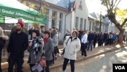 Des électeurs font la queue devant un bureau de vote en Afrique du Sud.