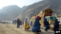Pengungsi Afghanistan berpakaian burqa tiba di pusat repatriasi Komisaris Tinggi PBB untuk Pengungsi (UNHCR) di Torkham, saat mereka melintasi perbatasan utama antara Afghanistan dan Pakistan untuk kembali ke negara asal mereka. (NOORULLAH SHIRZADA / AFP)