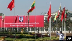 A traffic police stands on a road as he clears a road near a welcoming billboard to Chinese President Xi Jinping Friday, Jan. 17, 2020, in Naypyitaw, Myanmar.