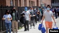 រូបឯកសារ៖ ពលរដ្ឋរង់ចាំខាងក្រៅកន្លែងចែកចាយអាហារនៅវិហារ Bartholomew ក្នុងក្រុងញូវយ៉ក សហរដ្ឋអាមេរិក កាលពីថ្ងៃទី១៥ ខែឧសភា ឆ្នាំ២០២០។ 