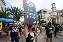 Demonstrators march near the White House and St. John's Church, right, ahead of the Fourth of July celebration on July 4, 2020, in Washington, D.C.