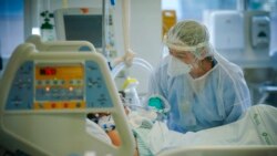 FILE - A health worker treats a COVID-19 patient in the ICU ward at the Hospital das Clinicas in Porto Alegre, Brazil, March 19, 2021.