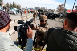 FILE - Afghan security police block a TV journalist from filming at the site of bombing attack in Kabul, Afghanistan, Feb. 10, 2021.