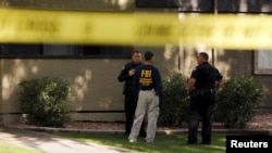 Seorang agen FBI berbicara dengan dua orang polisi di kompleks apartemen Autumn Ridge yang digeledah di Phoenix, Arizona (4/5).