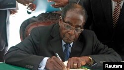 Zimbabwe President Robert Mugabe signs Zimbabwe's new constitution into law in Harare, May 22, 2013.