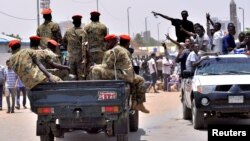 Sudanese demonstrators cheer as they drive towards a military vehicle, celebrating the ouster of President Omar al-Bashir, near the Defense Ministry in Khartoum, Sudan, April 11, 2019. (Reuters)
