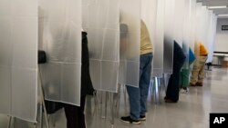 Voters fill out their ballot during early voting at the Cuyahoga County Board of Elections, Tuesday, Oct. 6, 2020, in Cleveland. (AP Photo/Tony Dejak)