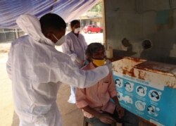 A health worker takes a nasal swab sample of a man at a COVID-19 testing center in Hyderabad, India, Jan. 2, 2021.